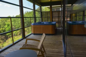A cozy hot tub on a cabin deck, surrounded by nature.